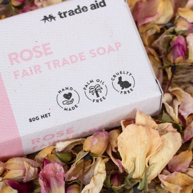 Rose Fair Trade Soap packaging from Trade Aid on a bed of dried rose petals.