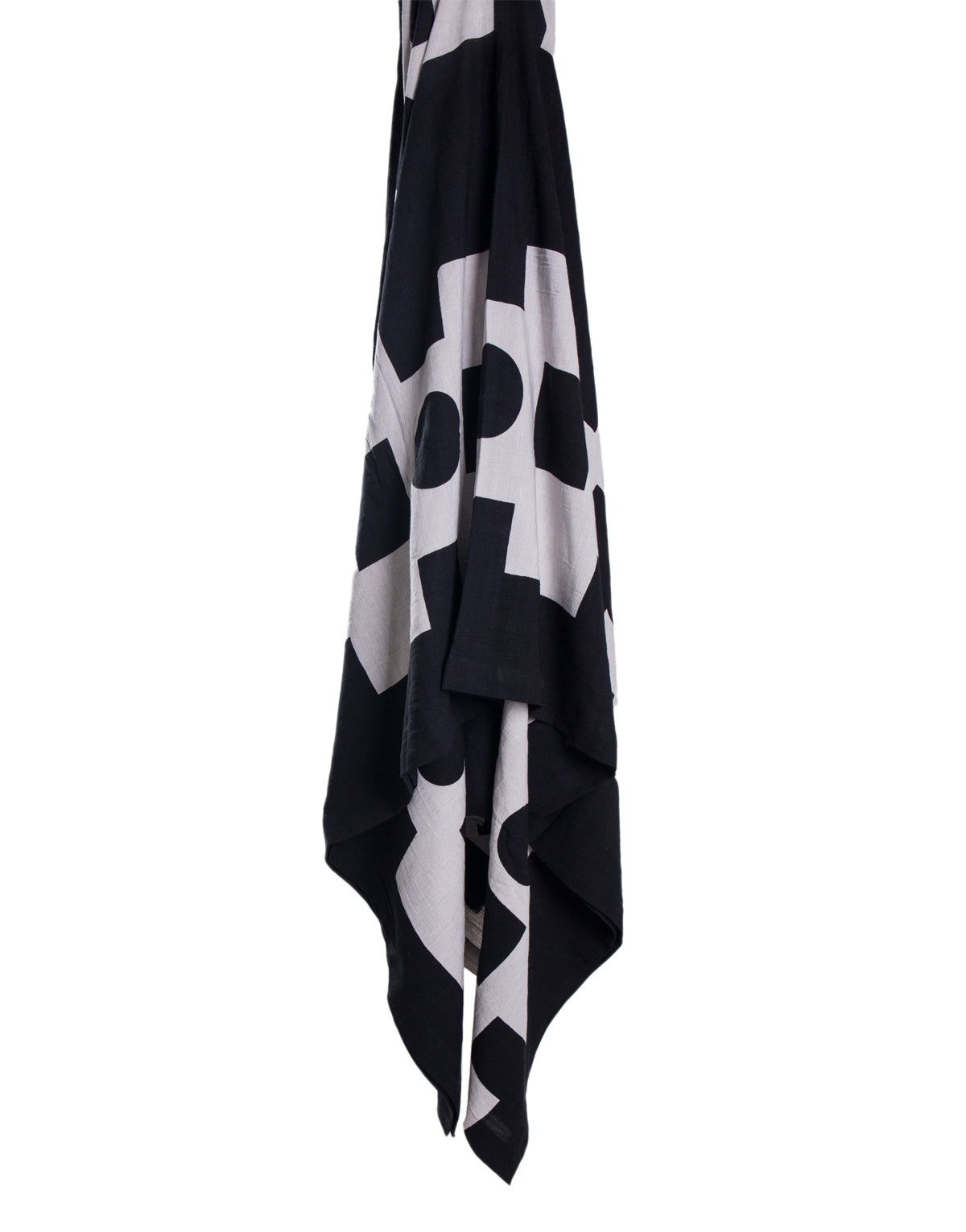 A black and white rayon linen throw draped across a flat white surface