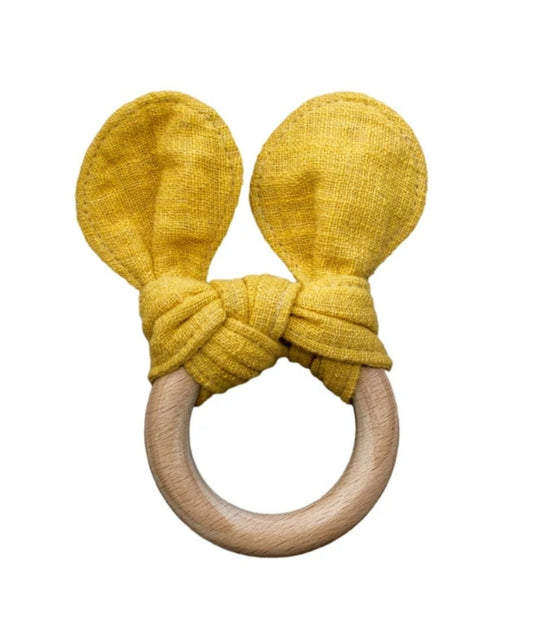 mustard yellow coloured baby teether on a wooden ring, with mustard linen ears