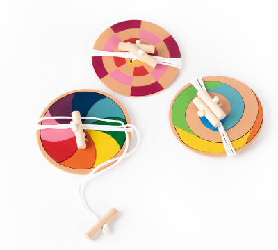 three coloured toy spinners on a white background