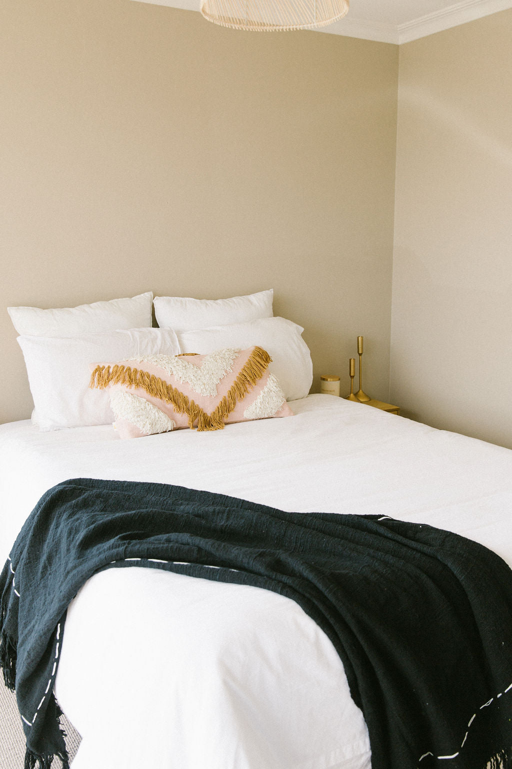 Bed with crisp white French linen bedding and decorative pillows in a bedroom setting