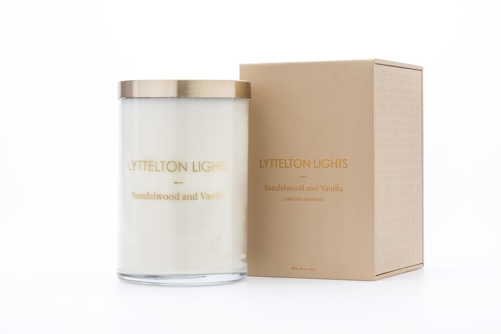 Lyttelton Lights Sandalwood and Vanilla candle with gold lid and matching tan packaging on a white background