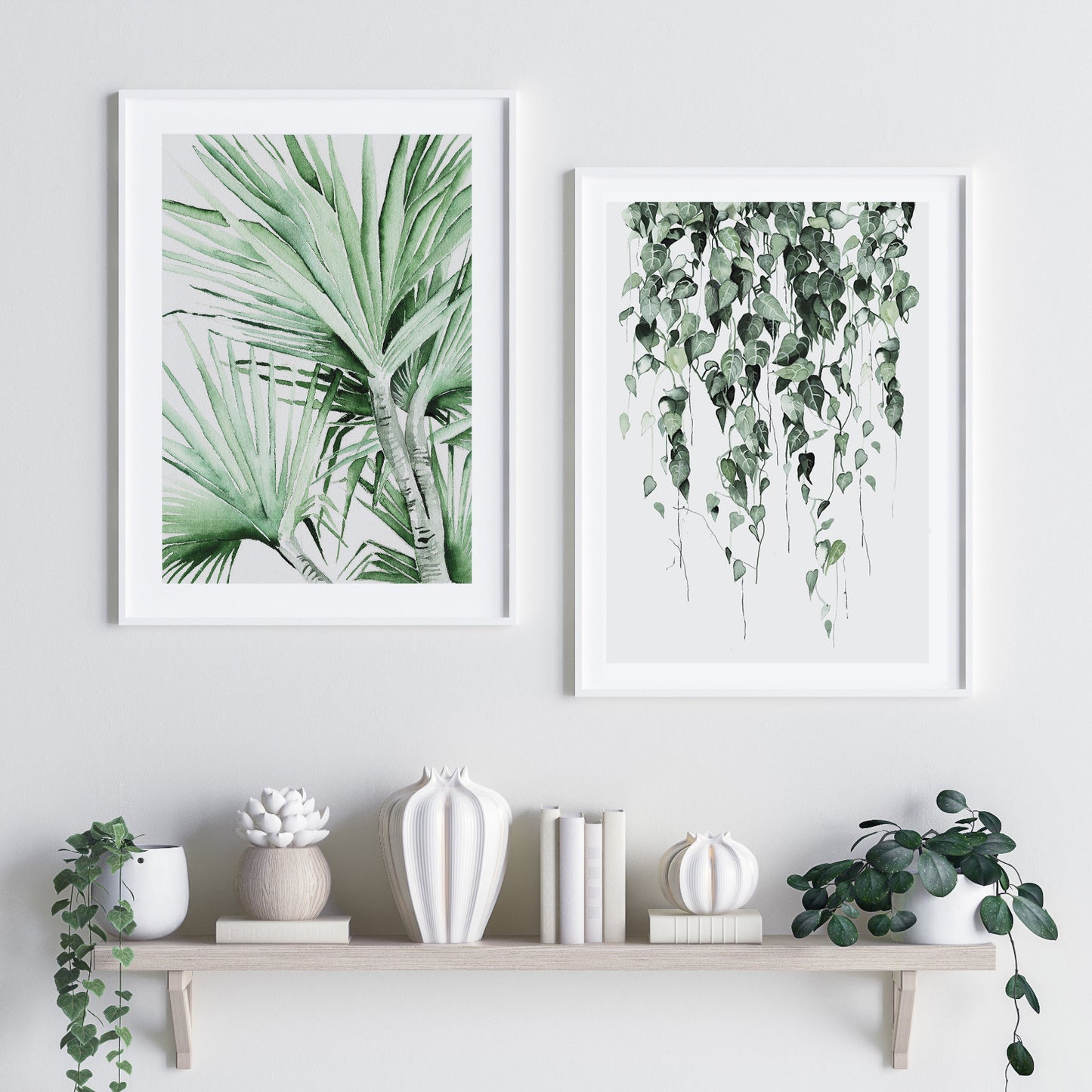watercolour artwork showing heart shaped leaves dangling from the top. Called "Falling Hearts" beside a painting of a palm tree, below the pictures is a floating shelf with a variety of vessels and pot plants sitting on it
