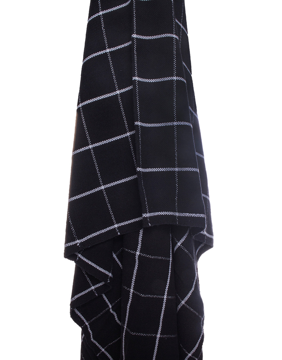 a black and white checkered design hand loomed cotton throw blanket, draped over a flat surface