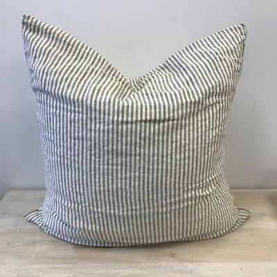 An Olive and White striped European Pillow made from French flax linen, sitting on a light wood surface with a light background. 