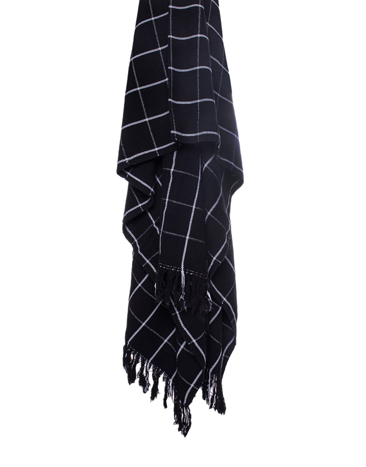 A black and white checkered hand loomed throw blanket draped over a flat surface. 
