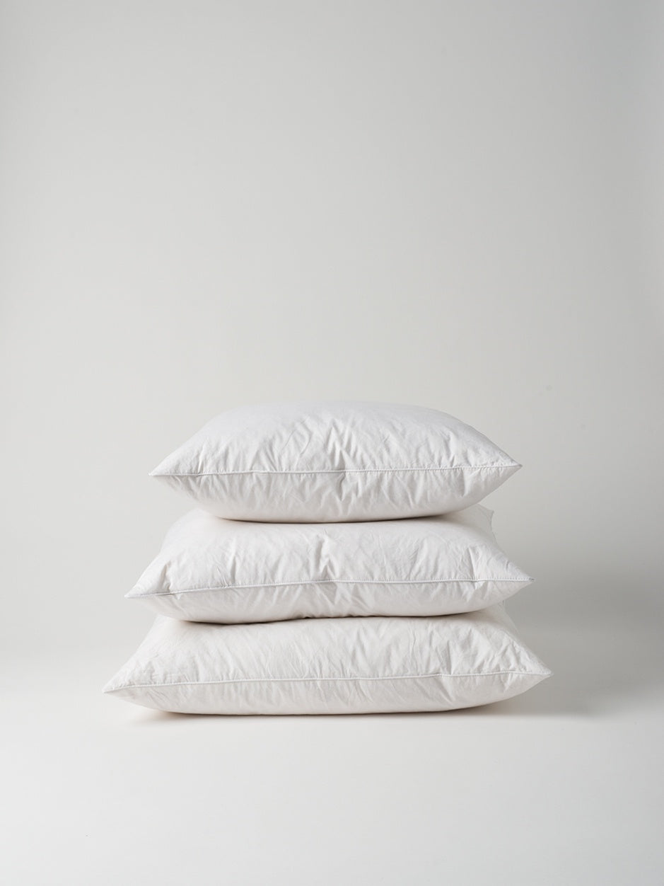Stack of white feather and down cushion inners, NZ homeware